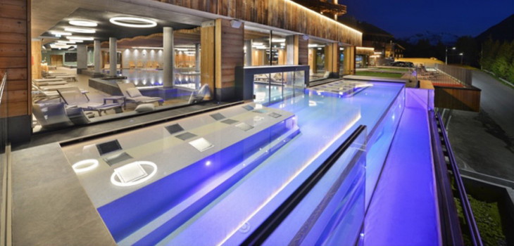 Piscina a sfioro trasparente realizzata con tecnologia Klimapool Floating di Preformati Italia