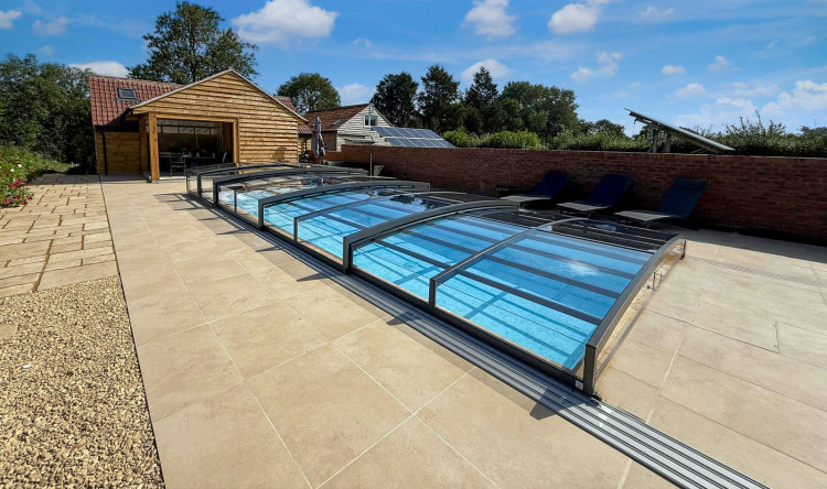 ALUKOV low-profile pool enclosure with single-sided track Low-profile ALUKOV telescopic pool enclosure with a single-sided track leaving the poolside area open and accessible