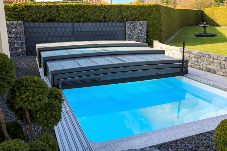 Title: ALUKOV telescopic pool enclosure with retractable segments ALUKOV telescopic pool enclosure partially opened, showing retractable segments that provide flexible access to the swimming pool