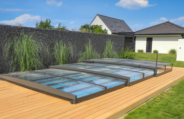 ALUKOV ultra-low pool enclosure with minimalist design Ultra-low ALUKOV pool enclosure closed over a residential swimming pool with minimal visual impact on the surrounding garden